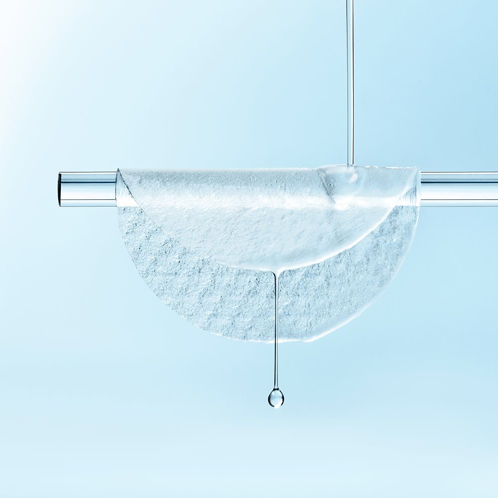 Pad rond sur une barre métallique. Liquide qui goutte. Arrière-plan: bleu clair.