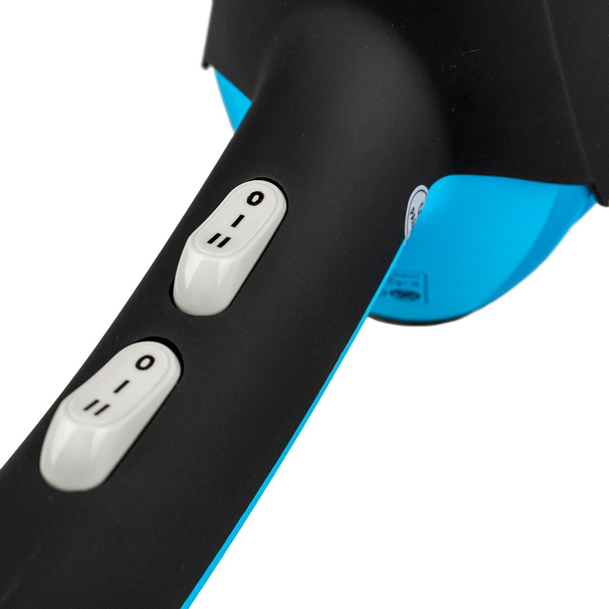 Gros plan sur la poignée du sèche-cheveux. Deux interrupteurs blancs avec marquages 0 et I.