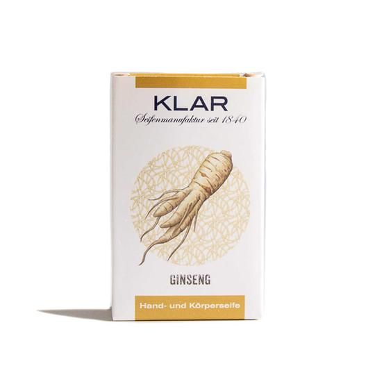 Klar zeepverpakking met ginseng illustratie. Tekst: KLAR, Ginseng, hand- en lichaamszeep. Witte doos met gouden accenten.