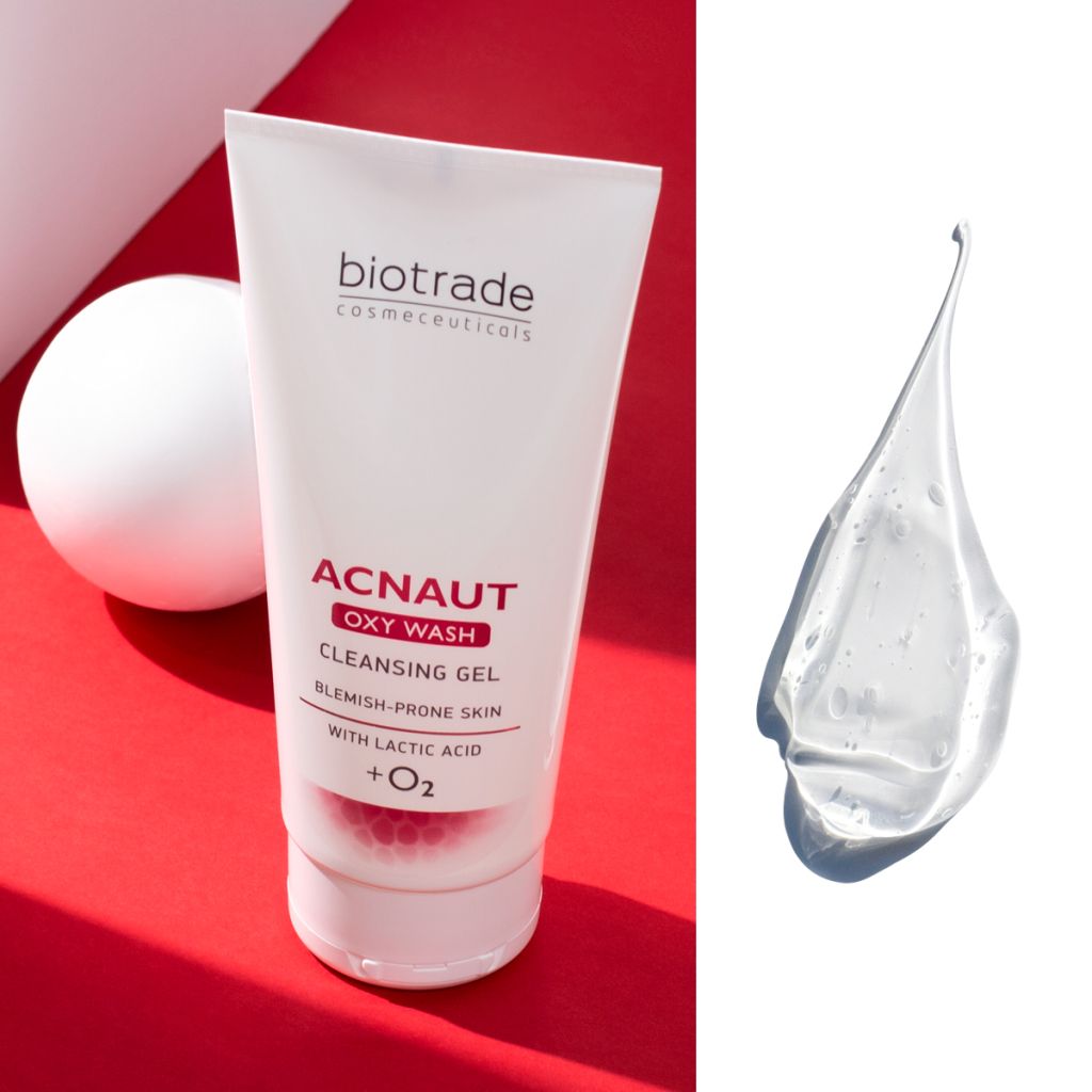 Tube de gel nettoyant blanc avec texte rouge. Nom du produit : Acnaut Oxy Wash. Goutte de gel à côté.