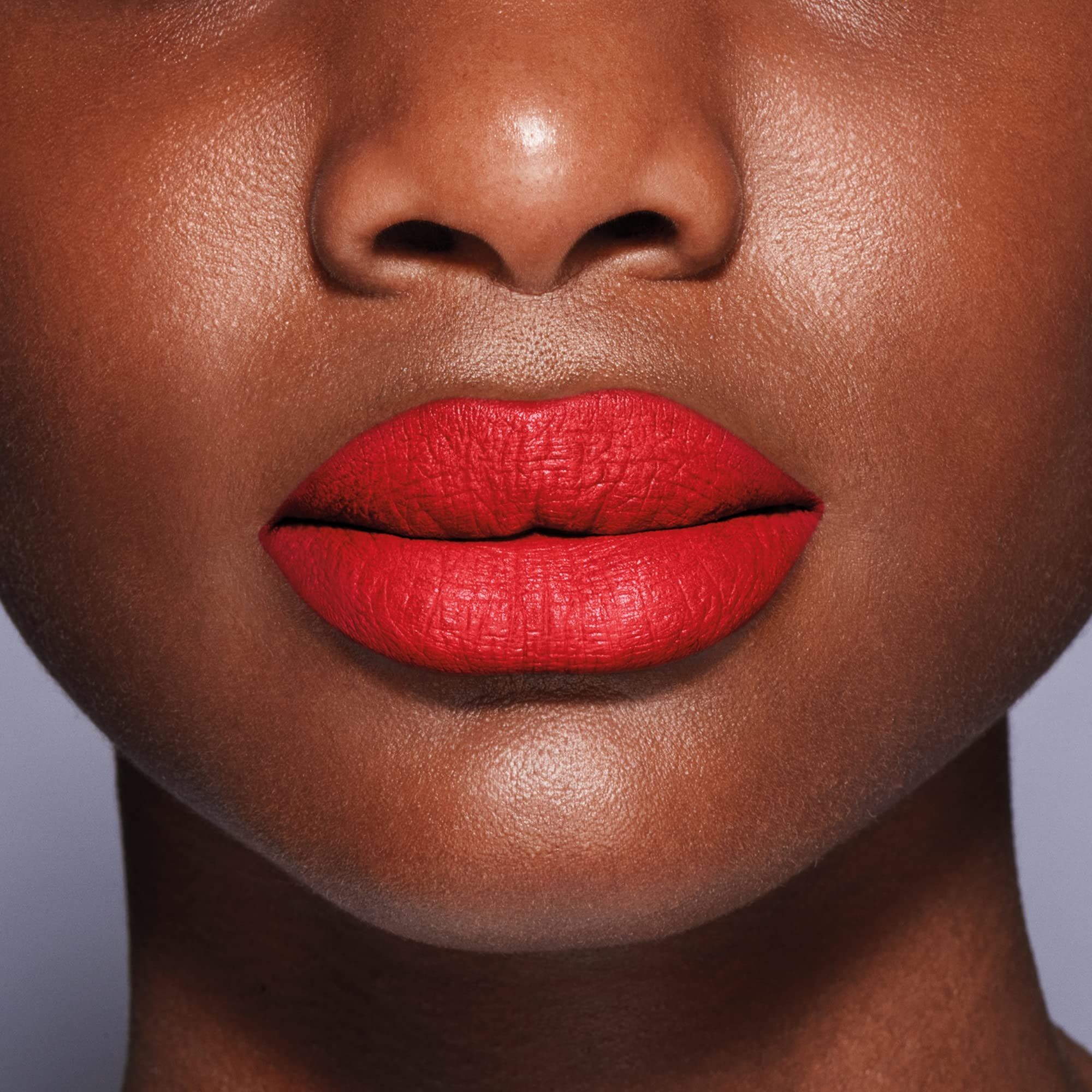 Close-up van lippen met rode lipstick. Matte textuur, gelijkmatige applicatie.