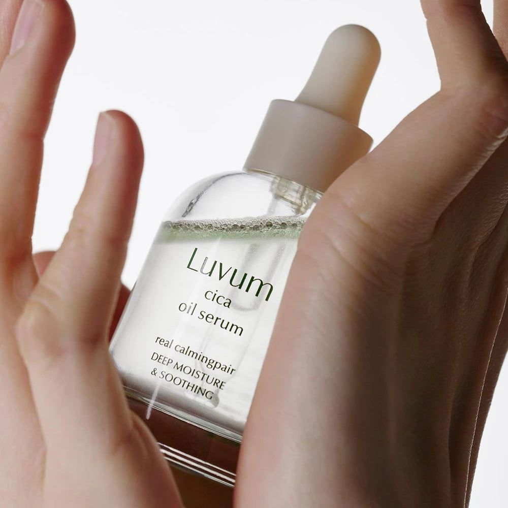 Handen houden een serumflesje vast. Opschrift: Luvum cica oil serum. Tekst: real calming repair, deep moisture & soothing.