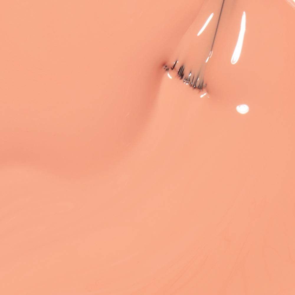 Perzik kleurige nagellak. Penseel met lak. Close-up. Glanzend oppervlak.