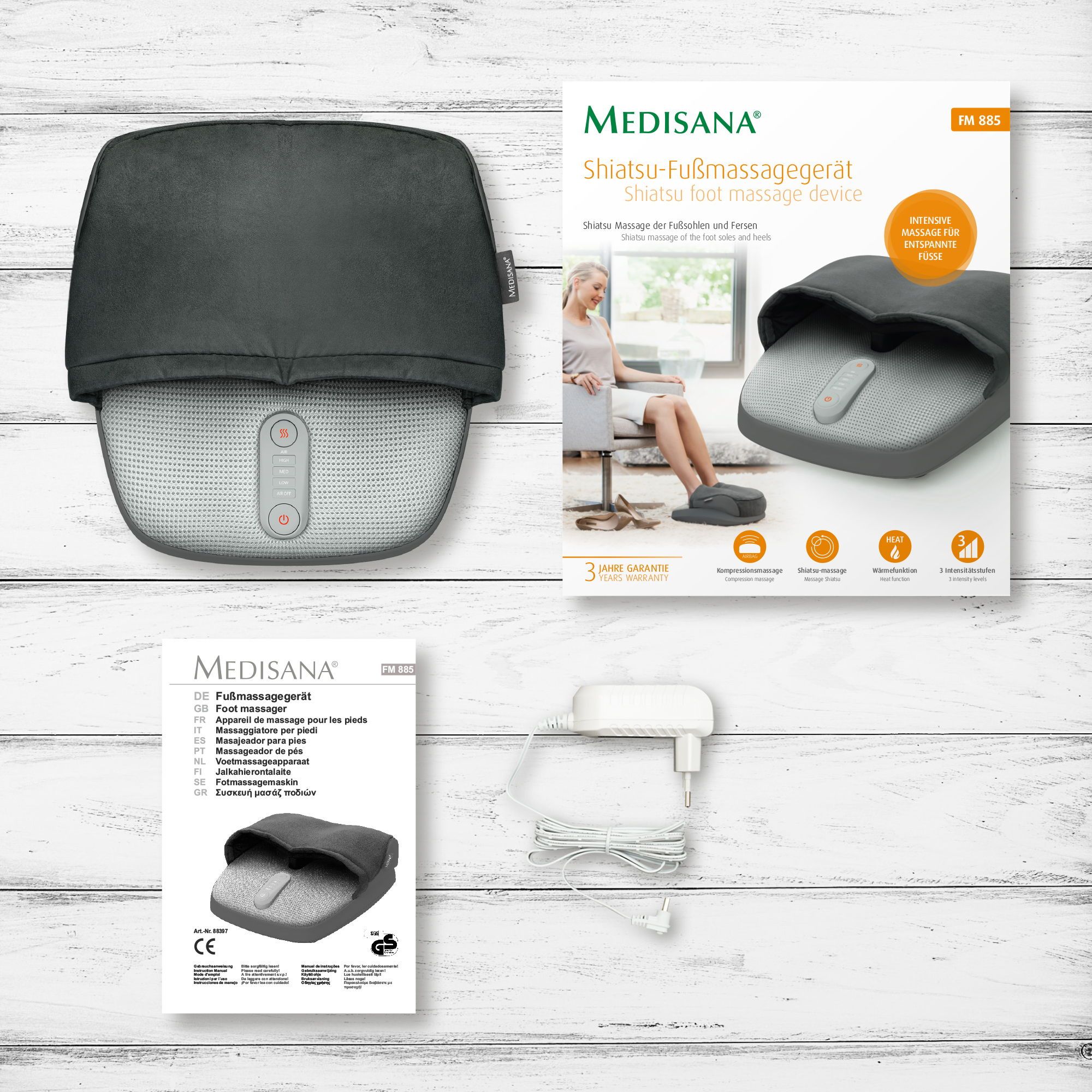 Shiatsu voetmassageapparaat met verpakking, handleiding en adapter.