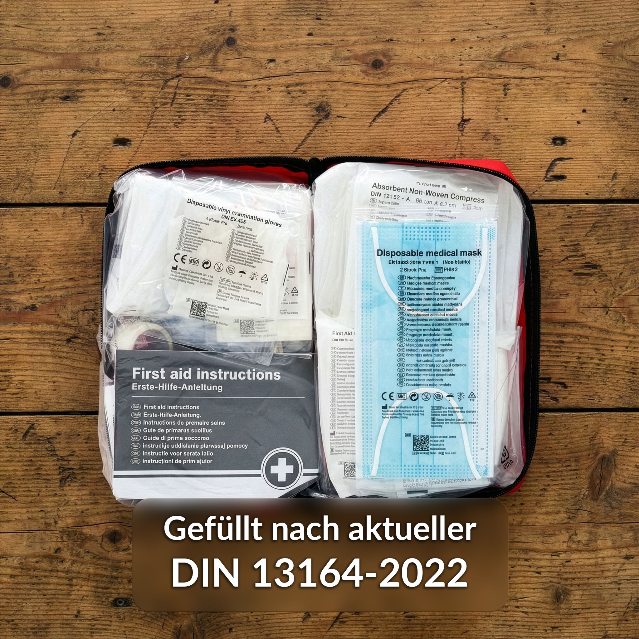 Trousse de premiers secours ouverte avec fournitures. Contient bandages, masque, gants, instructions. DIN 13164-2022.
