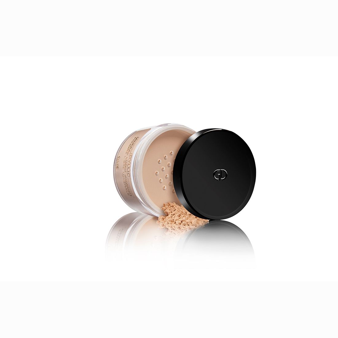 Ga-De Idyllic Mineral Loose Powder. Pot met zwarte deksel. Poeder verspreid op witte achtergrond.