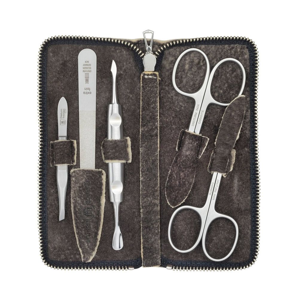 Étui manucure en daim ouvert. Ciseaux à ongles, lime, coupe-ongles et autres instruments. Fermeture éclair.