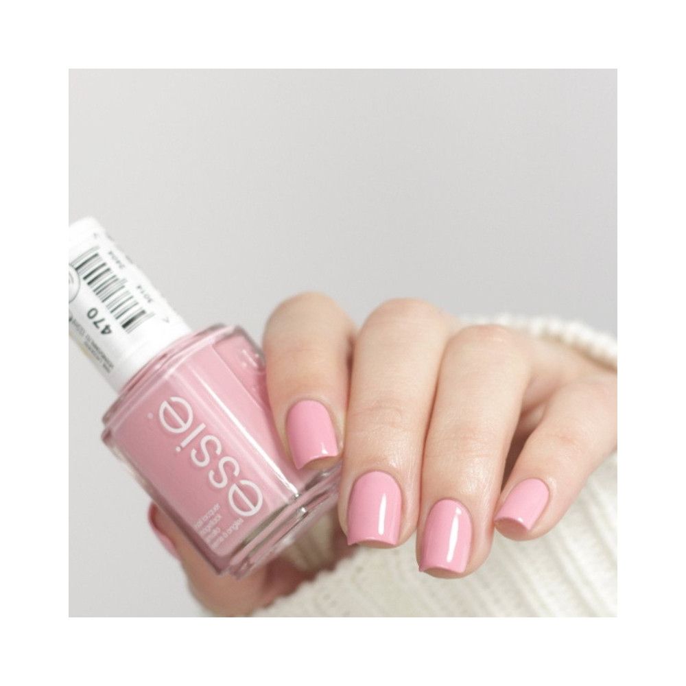 Essie roze nagellakfles. Hand met gelakte nagels. Label met productnummer.