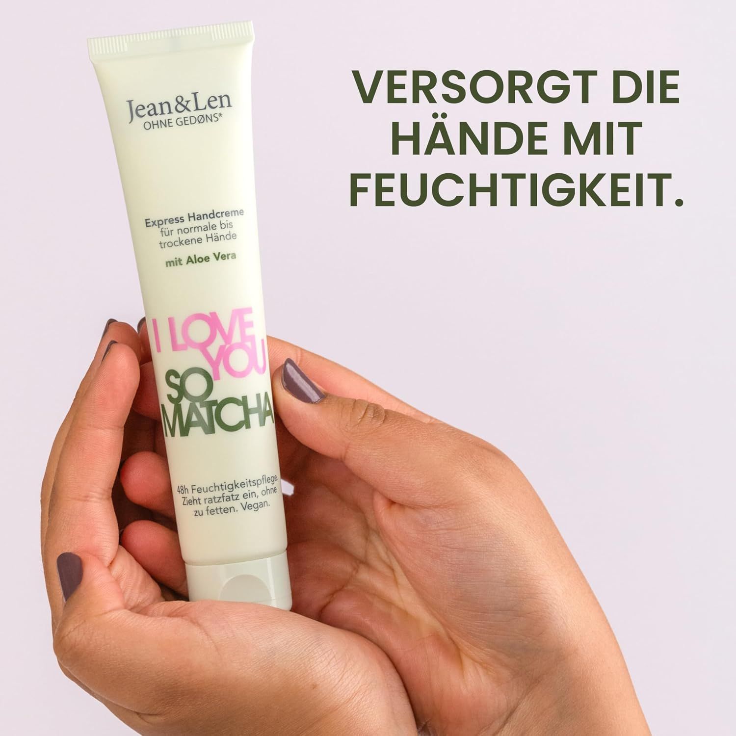 Tube de crème pour les mains dans les mains. Texte : I Love You So Matcha. Hydrate les mains. Tube clair avec texte vert et rose.
