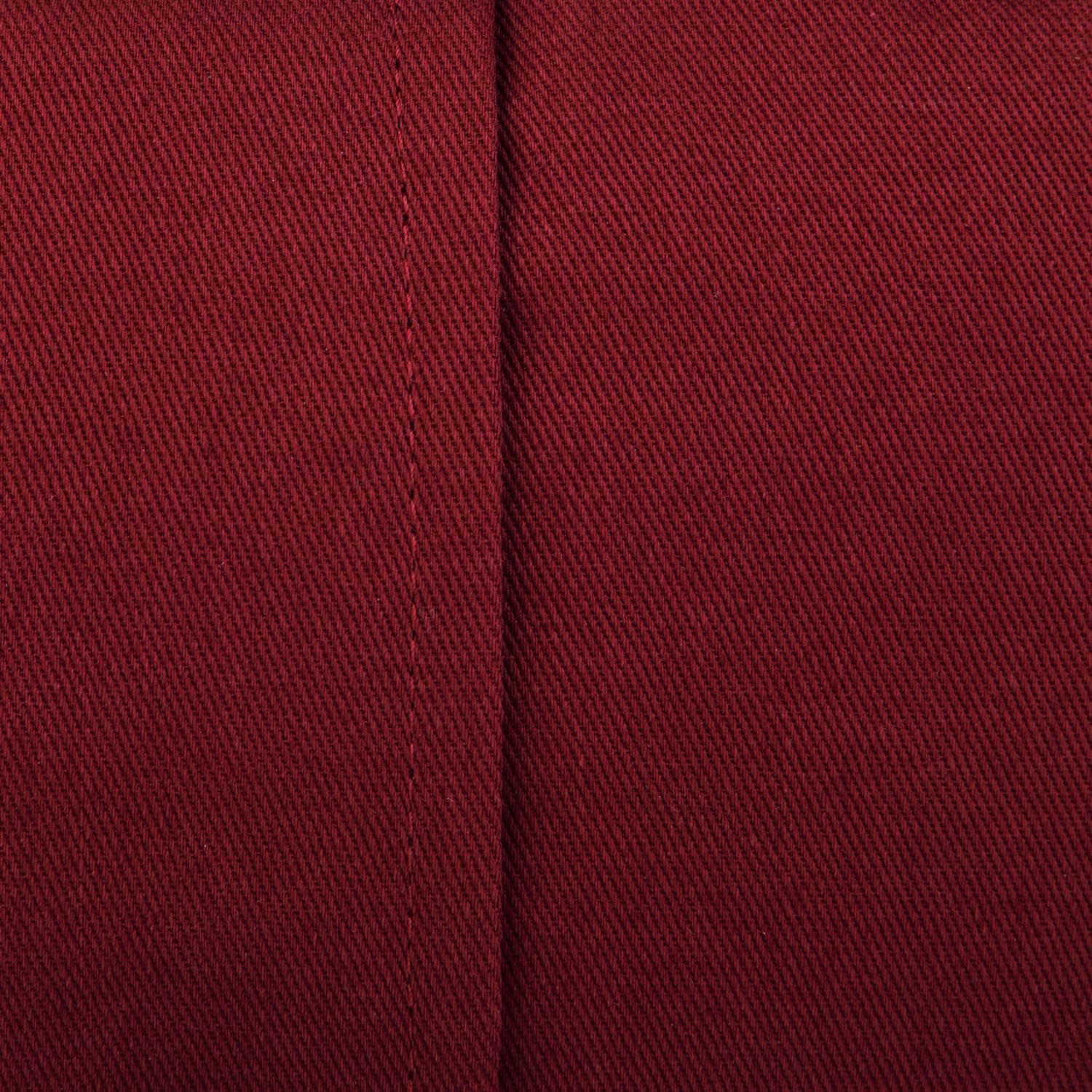 Texture de tissu d'un coussin de méditation bordeaux en demi-lune avec coutures visibles.