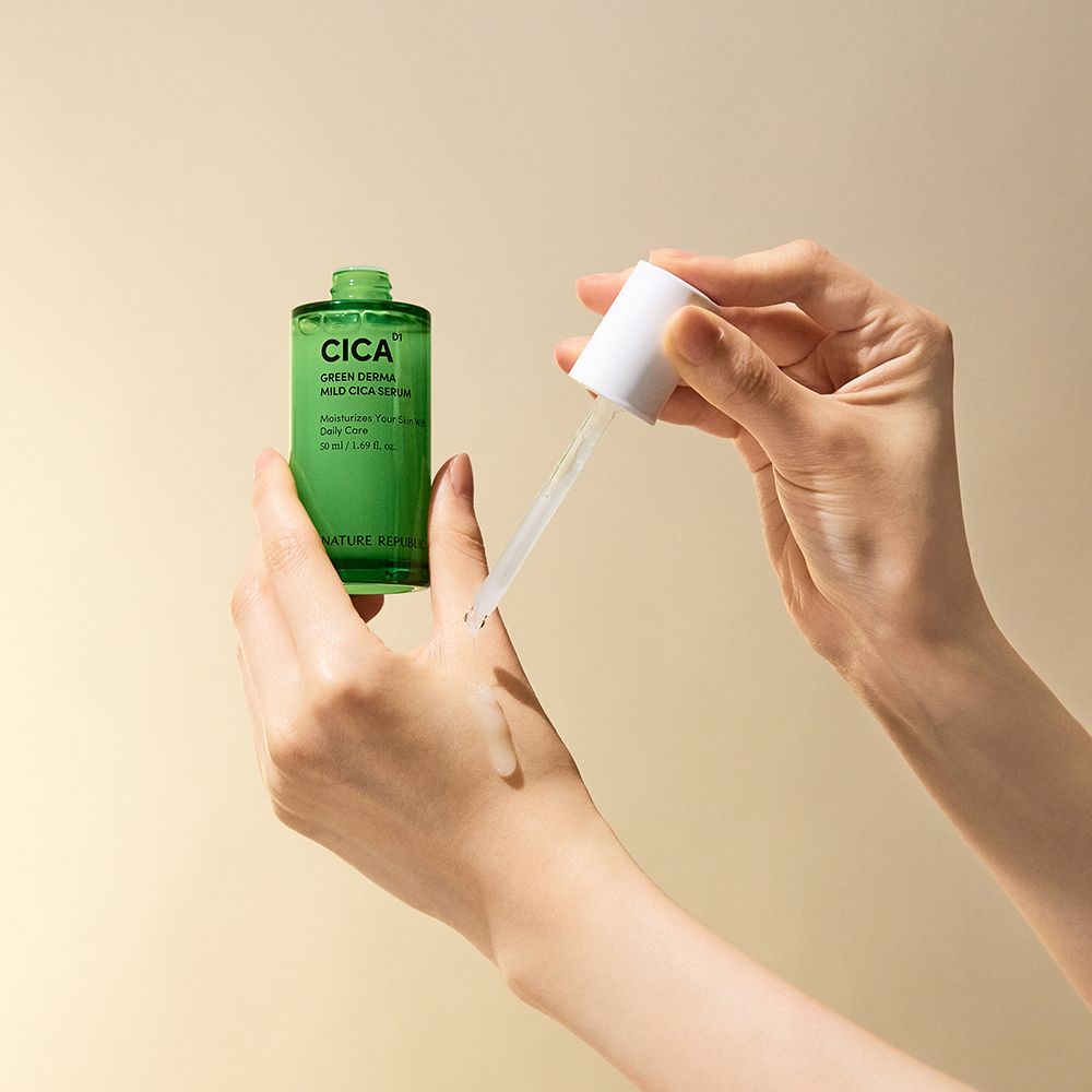 Mains tenant un flacon de sérum et une pipette. Le sérum est appliqué sur la main. Inscription : CICA, GREEN DERMA MILD CICA SERUM.