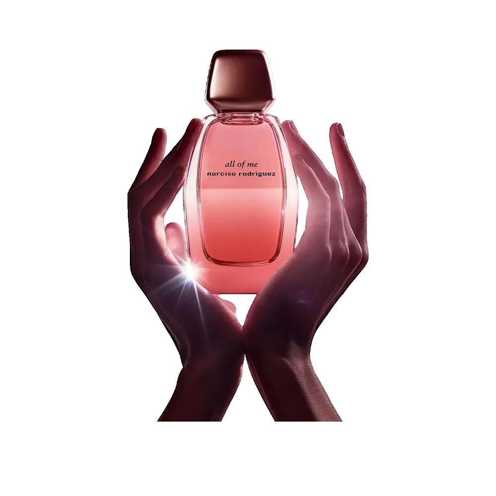 Roze parfumfles, gouden dop. Handen houden fles vast. Opschrift: all of me, narciso rodriguez.
