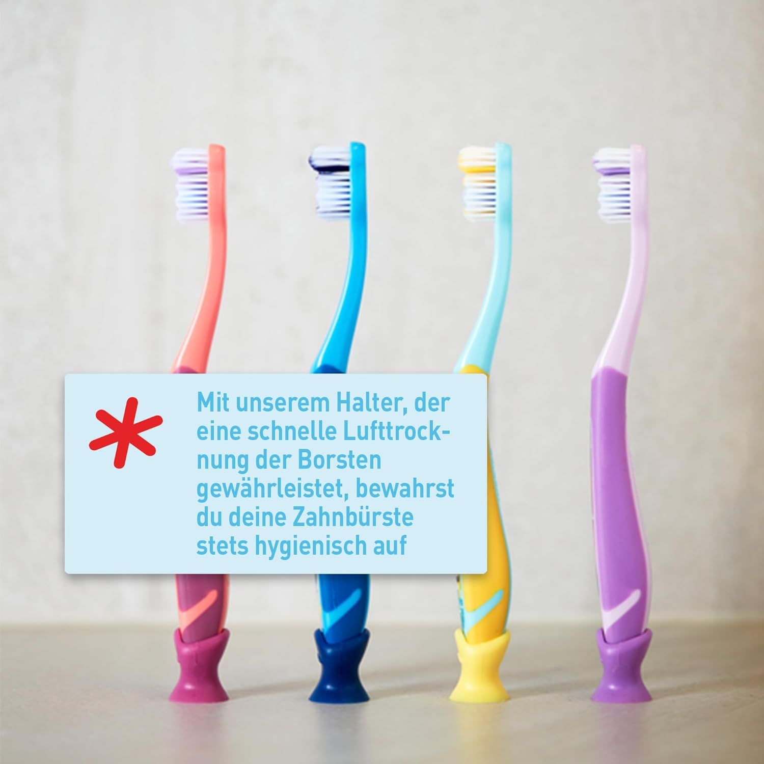 Quatre brosses à dents avec manches colorées. Rose, bleu, jaune et violet. Avec support pour séchage à l'air des soies.