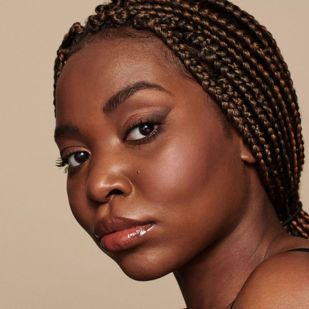 Portrait d'une femme avec des tresses. Elle porte du maquillage pour les yeux.
