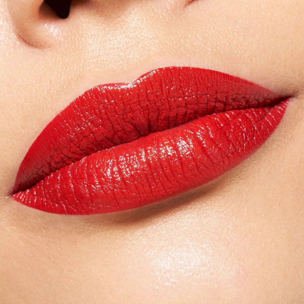Gros plan sur des lèvres rouges. Les lèvres sont couvertes de rouge à lèvres rouge.