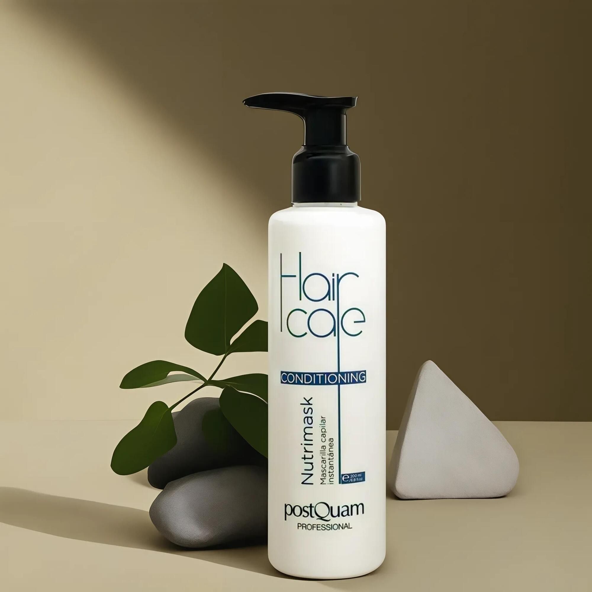 Witte fles met zwarte pomp. 'Hair Care Conditioning' en 'Nutrimask' van Postquam. Decoratie met bladeren en steen.