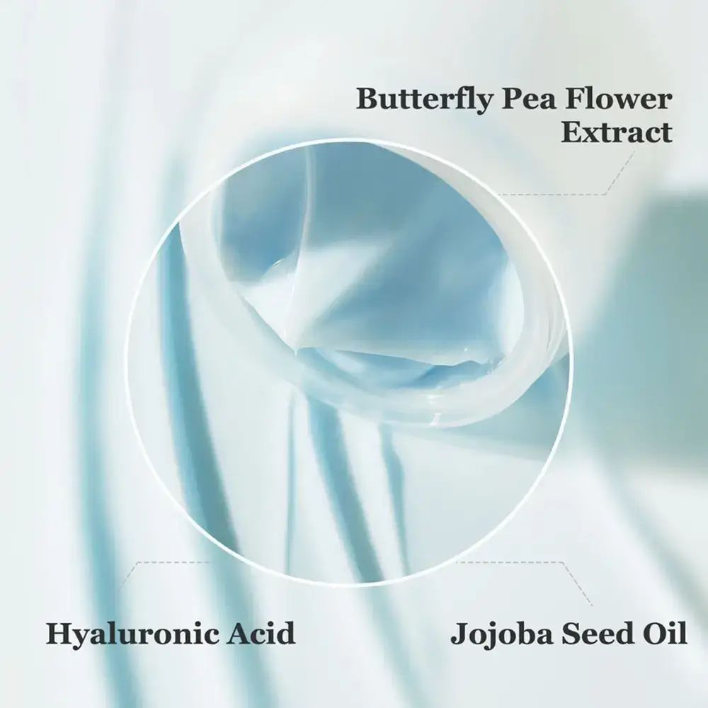 Gros plan sur le pot de crème. Inscriptions : Acide hyaluronique, Huile de graines de jojoba, Extrait de fleur de pois papillon.