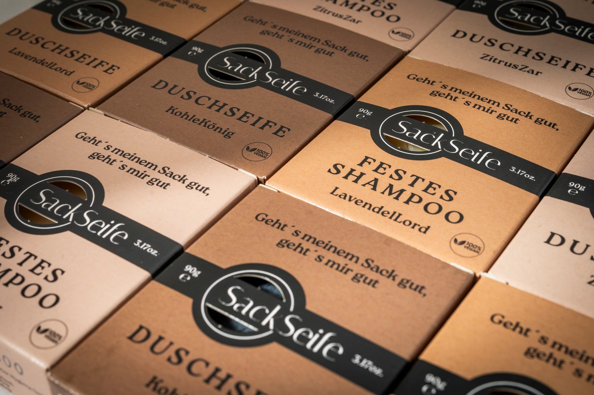 Meerdere dozen vaste shampoo. Verschillende soorten. Logo en tekst op de verpakkingen. Vegan-zegel.