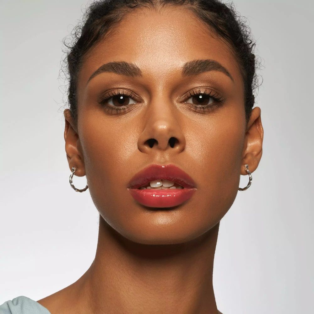 Portret van een vrouw met glanzende lipgloss op de lippen. Roze tint.