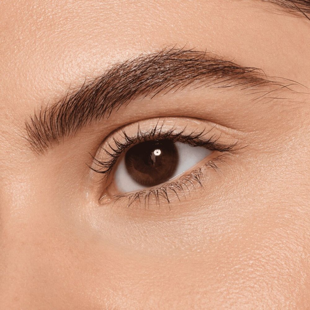 Close-up van een oog met wenkbrauw. Bruine ogen, donkere wimpers, verzorgde wenkbrauw.
