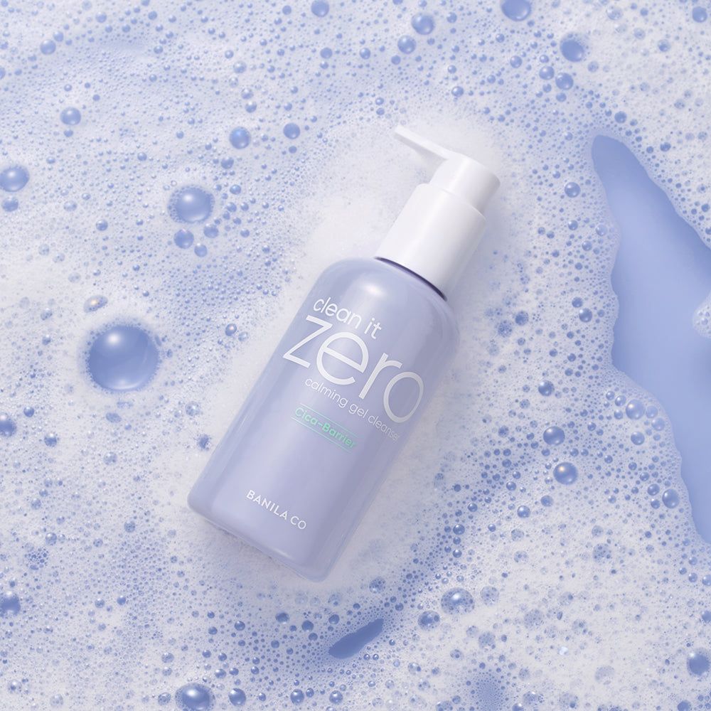 Fles met pomp. Opschrift: Clean it Zero, Calming Gel Cleanser. Omringd door zeepbellen.