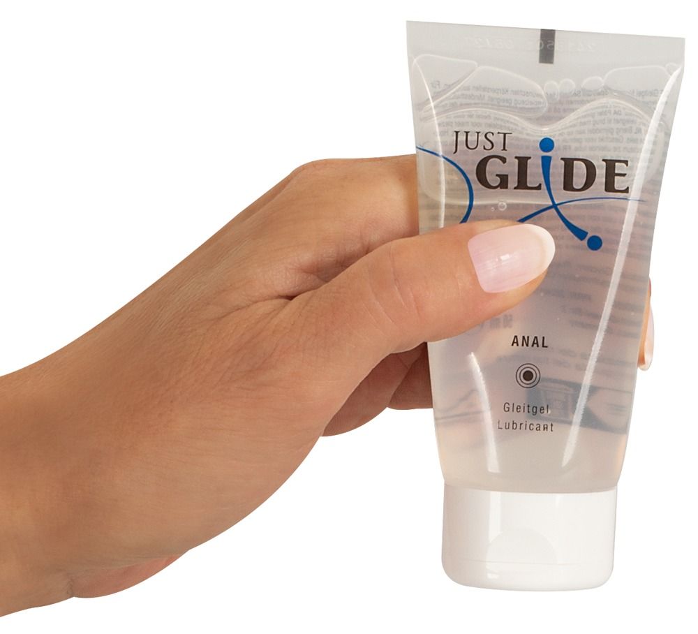 Hand houdt tube vast. Opschrift: JUST GLIDE ANAL. Glijmiddel Lubricant.