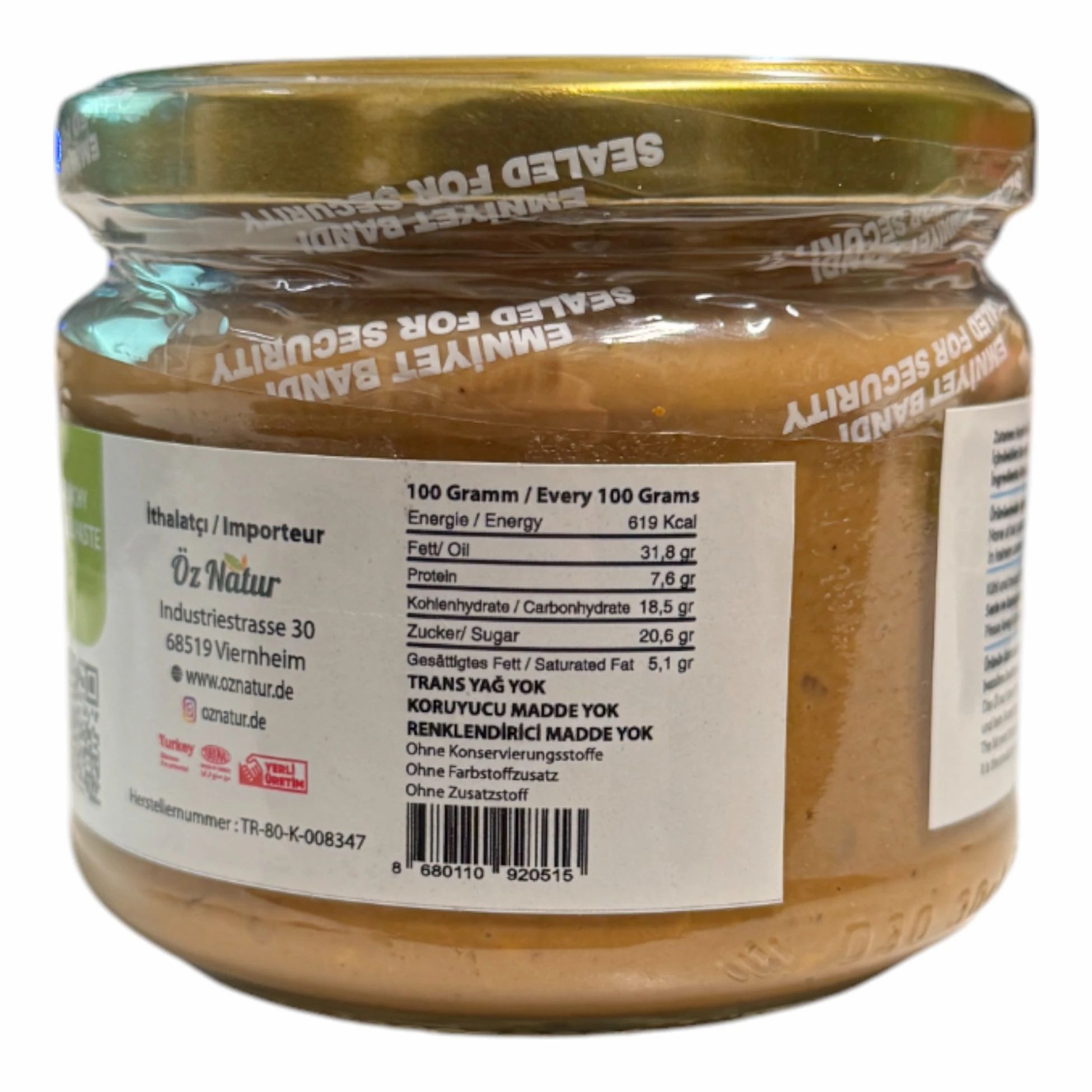 Achterkant van een pot amandelpasta. Tekst met voedingsinformatie. Zegel: Emniyet Bandi. Opschrift: 100 gram / Every 100 Grams.