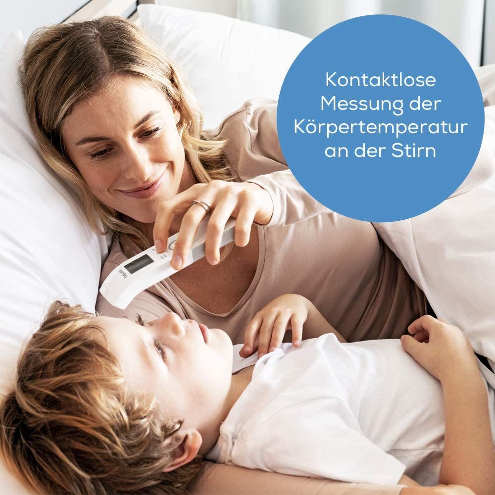 Moeder meet koorts bij kind met contactloze thermometer. Kind ligt in bed. Tekst: Contactloze meting van lichaamstemperatuur op het voorhoofd.