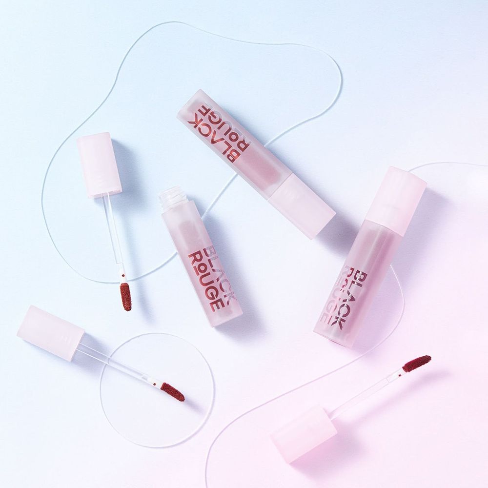 Plusieurs tubes de gloss avec applicateurs. BLACK ROUGE est écrit sur les tubes. Les applicateurs sont colorés.