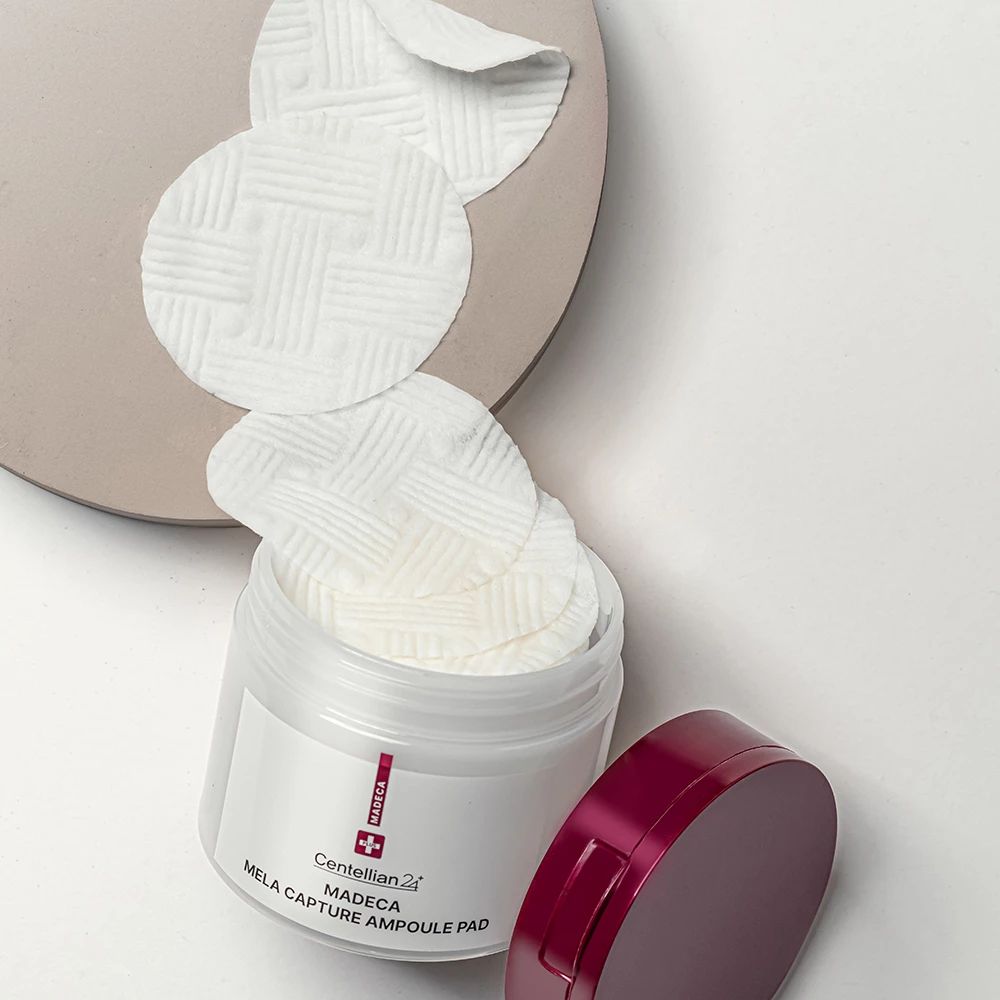 Boîte ouverte avec tampons. Tampons sur un plateau. Inscription: Madeca Mela Capture Ampoule Pad. Marque: Centellian 24.