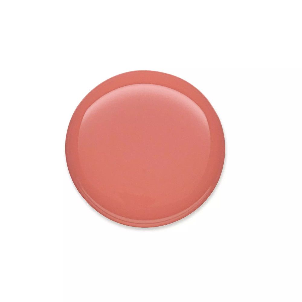 Tache ronde de vernis à ongles rose sur fond blanc. Surface brillante.