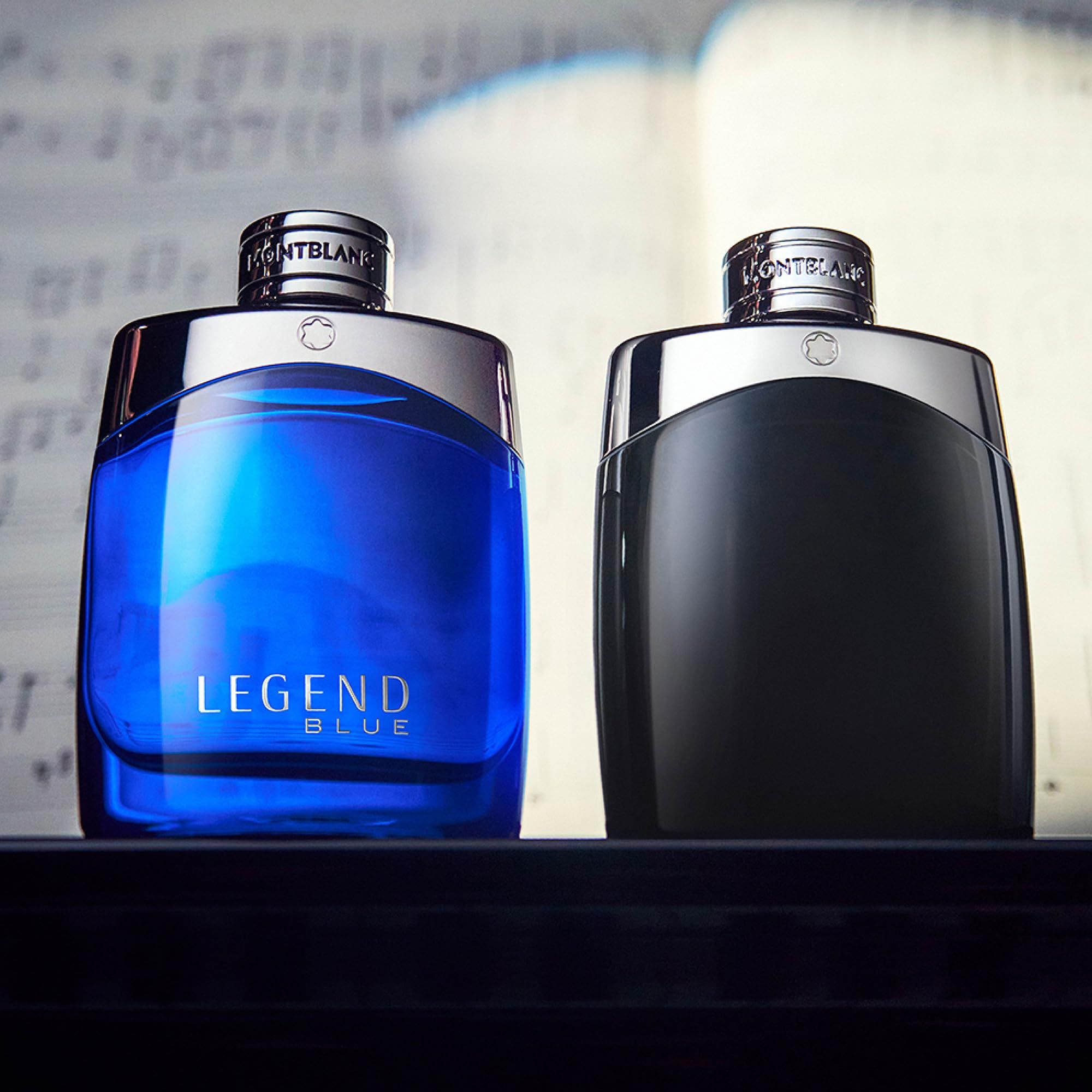 Twee Montblanc Legend parfumflacons: één blauw met "LEGEND BLUE" opschrift, de ander zwart. Zilveren doppen met logo.