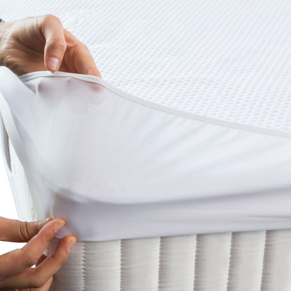 Handen trekken een wit hoeslaken over een matras. Toont de pasvorm en de pasvorm.
