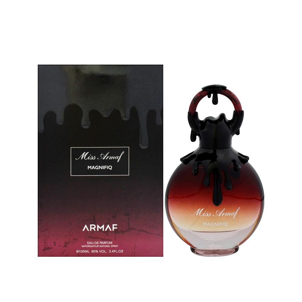 Parfumfles en verpakking. Ronde fles, rood-bruin, met zwarte dop. Zwarte verpakking met tekst.