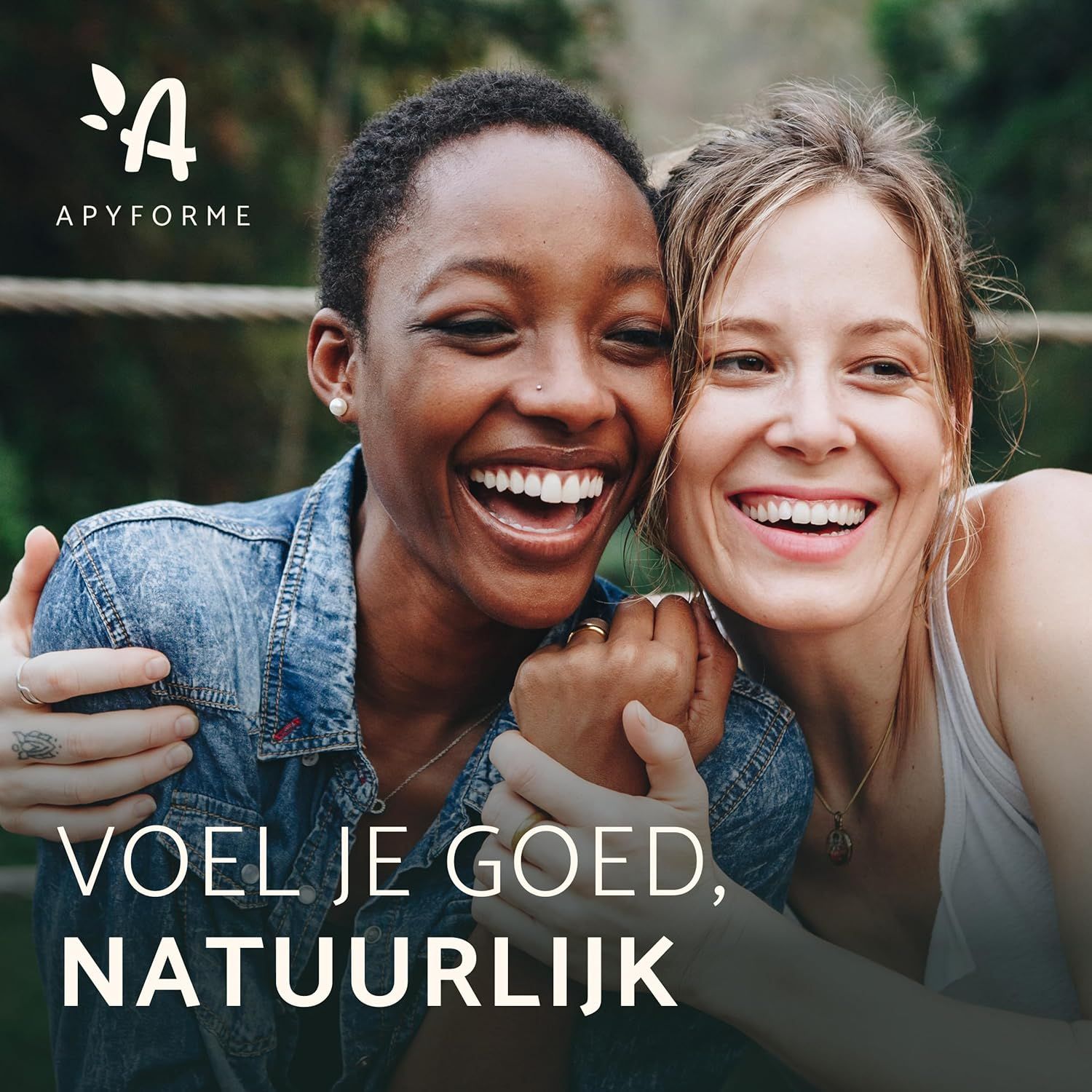 Twee lachende vrouwen, een donkere, een lichte huidskleur, omhelzen elkaar. Logo en tekst "APYFORME VOEL JE GOED, NATUURLIJK" boven en onder.
