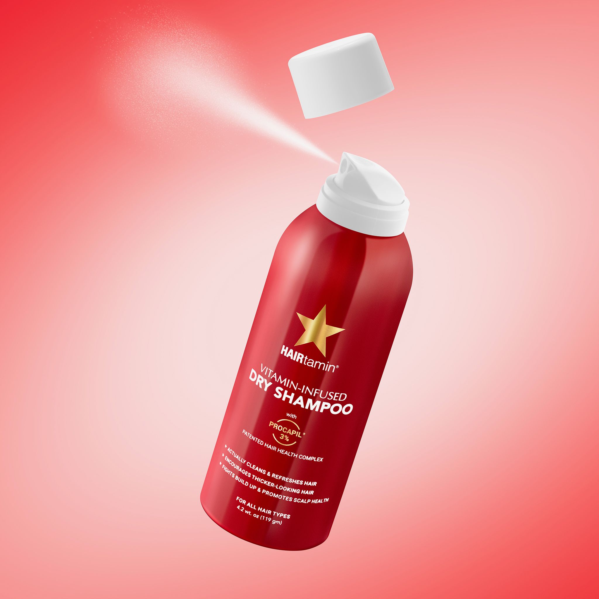 Rode spuitfles, spray. Productnaam: HAIRtamin Vitamin-Infused Dry Shampoo. Bevat Procapil. Voor alle haartypes.