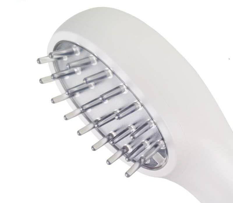 Close-up van de kop van een witte laser haarwuskam met transparante pinnen.