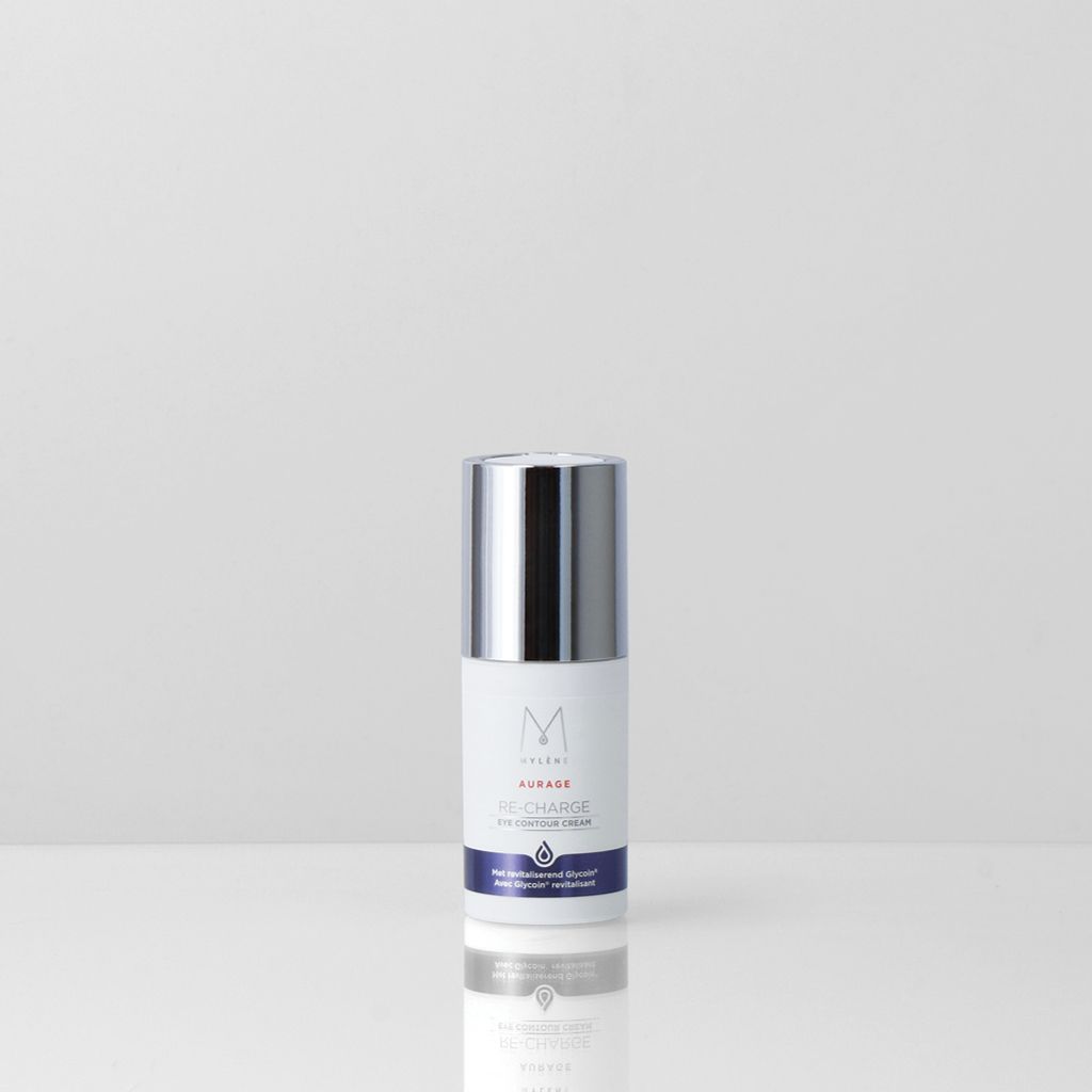 Crème contour des yeux Mylène Aurage Re-Charge Nuit dans un flacon blanc avec un capuchon argenté, sur une table.