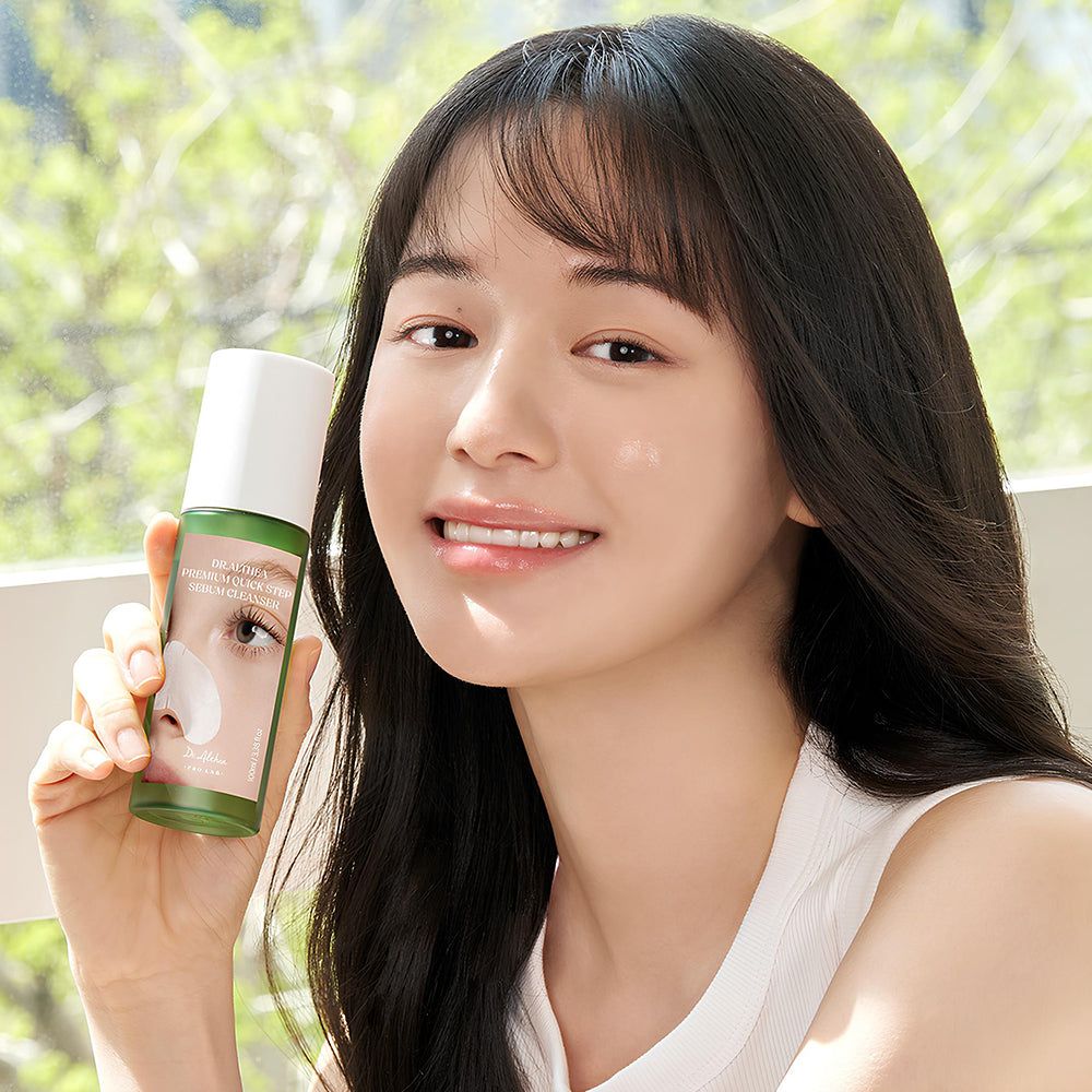Une femme tenant un flacon de Dr. Althea Premium Quick Step Sebum Cleanser.