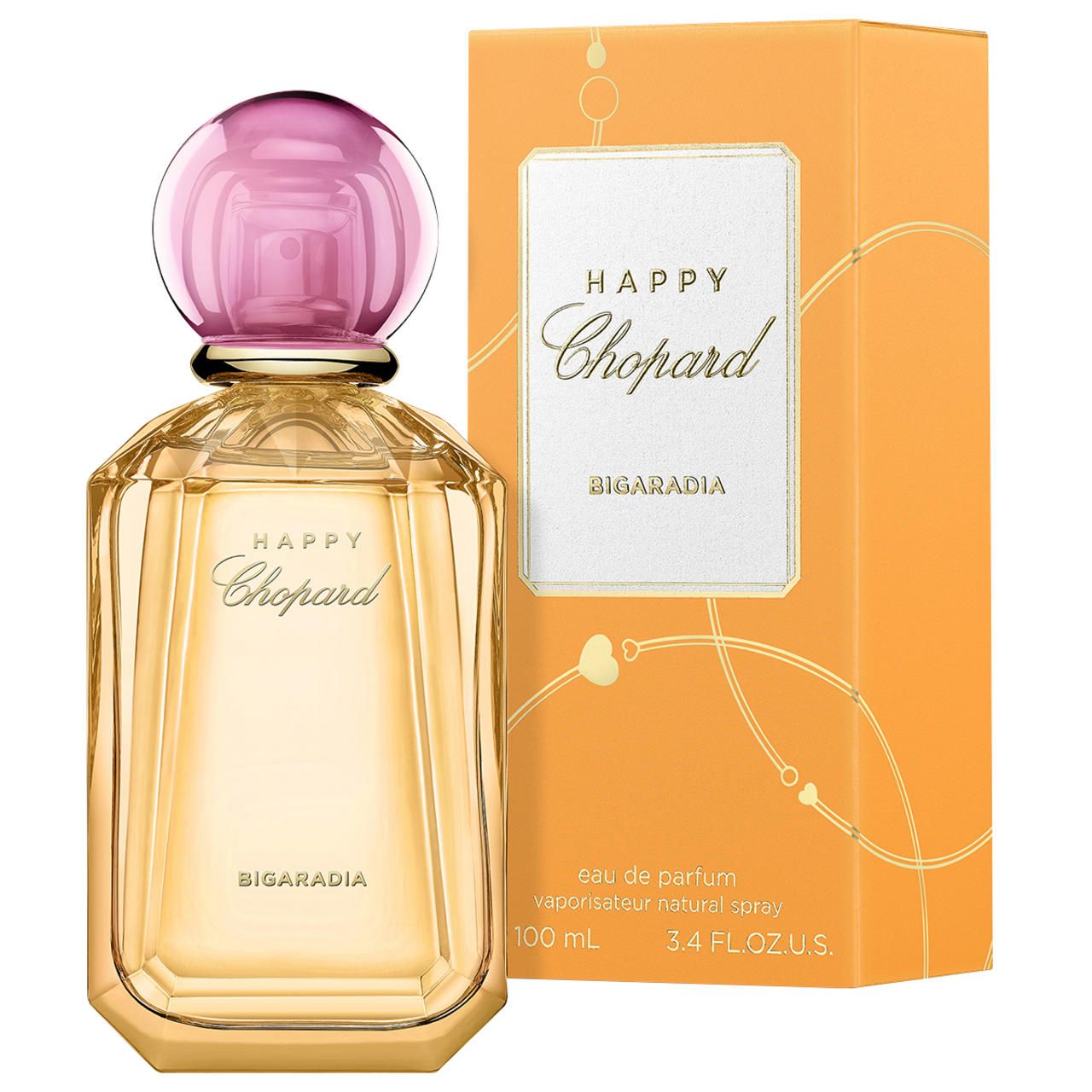 Parfumfles en verpakking. Fles met roze dop, goudkleurig glas. Oranje verpakking met wit etiket en opschrift Happy Chopard.