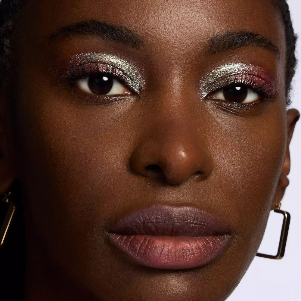 Gros plan d'un visage avec de l'ombre à paupières sur les paupières.