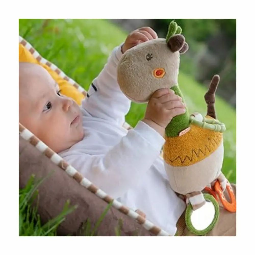 Bébé tenant une girafe en peluche. Beige, vert et jaune. Anneaux et miroirs. Inscription "Lotta". Bébé est dans un transat.