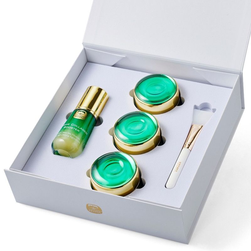 Verzorgingsset in witte doos. Bevat serum, drie potjes groene crème en een penseel. Gouden deksels en accenten.