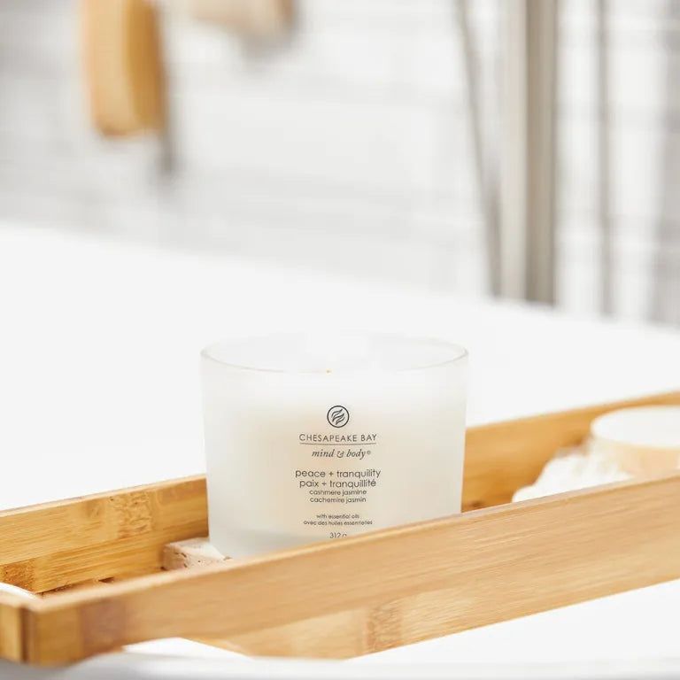 Witte glazen kaars op bamboe dienblad. Tekst: Chesapeake Bay, mind & body, peace + tranquility, Paix + tranquillité.