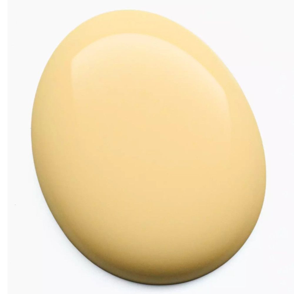 Goutte de vernis à ongles jaune sur fond blanc. La forme est ovale.