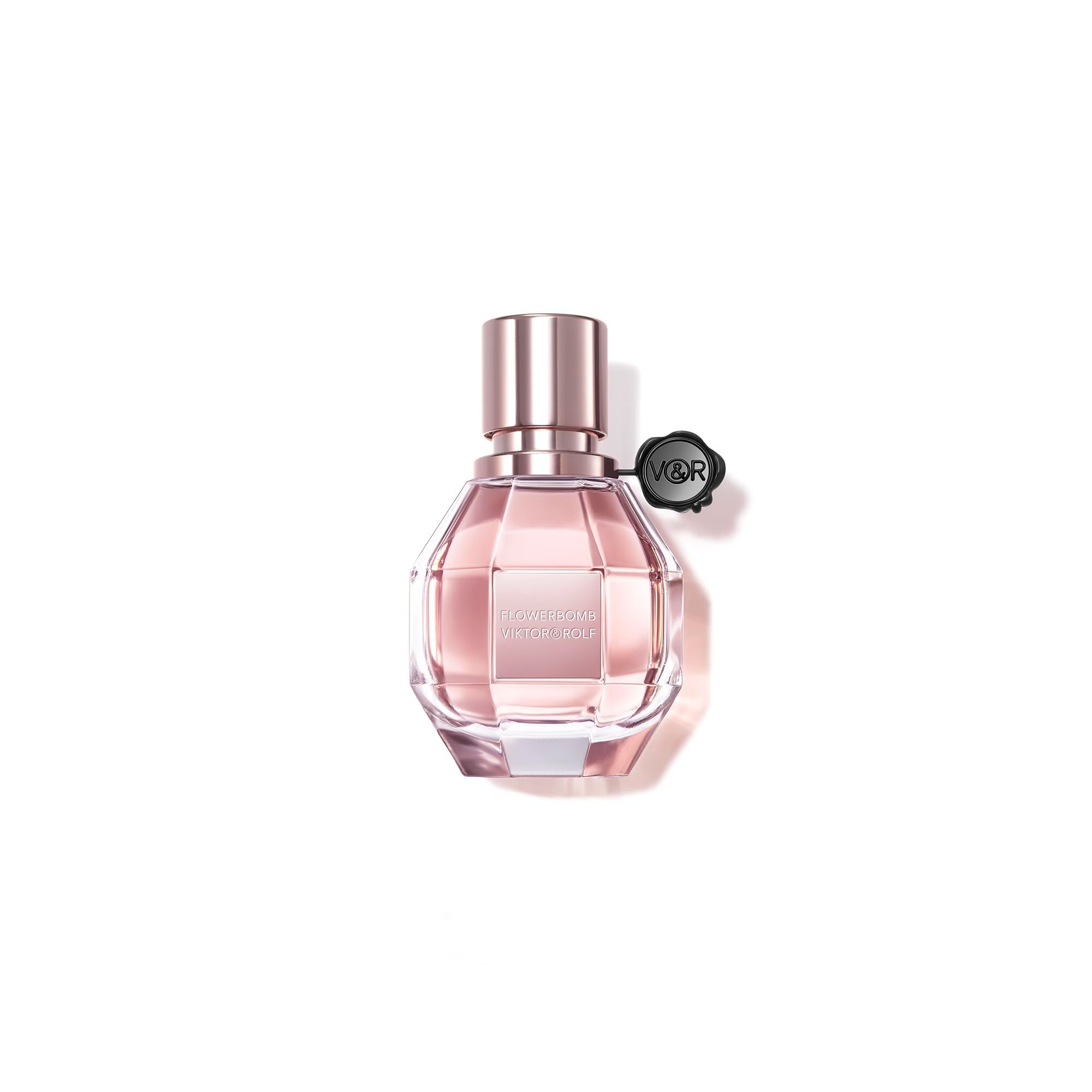 Flacon de parfum Flowerbomb de Viktor & Rolf. Liquide rose dans un flacon en verre facetté avec bouchon or rose.