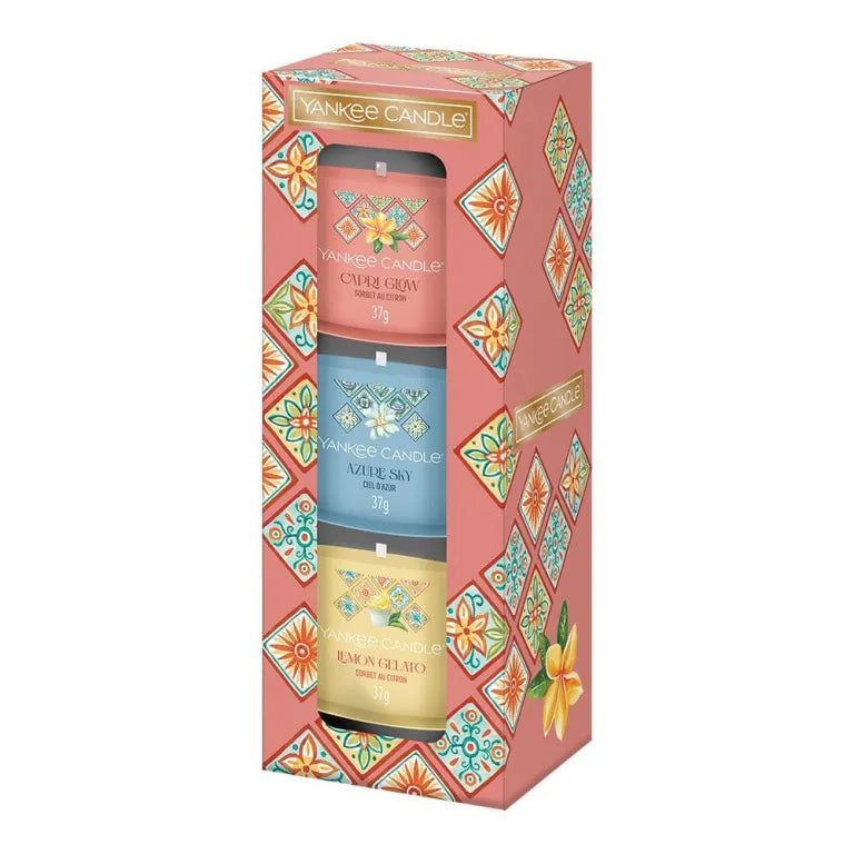 Coffret cadeau Yankee Candle avec 3 bougies votives. Emballage rose à motifs floraux. Bougies roses, bleues et jaunes.