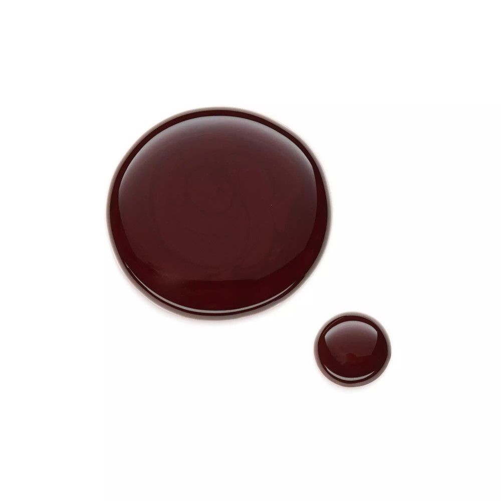 Deux gouttes de vernis à ongles bordeaux sur fond blanc. Une grande et une petite goutte.