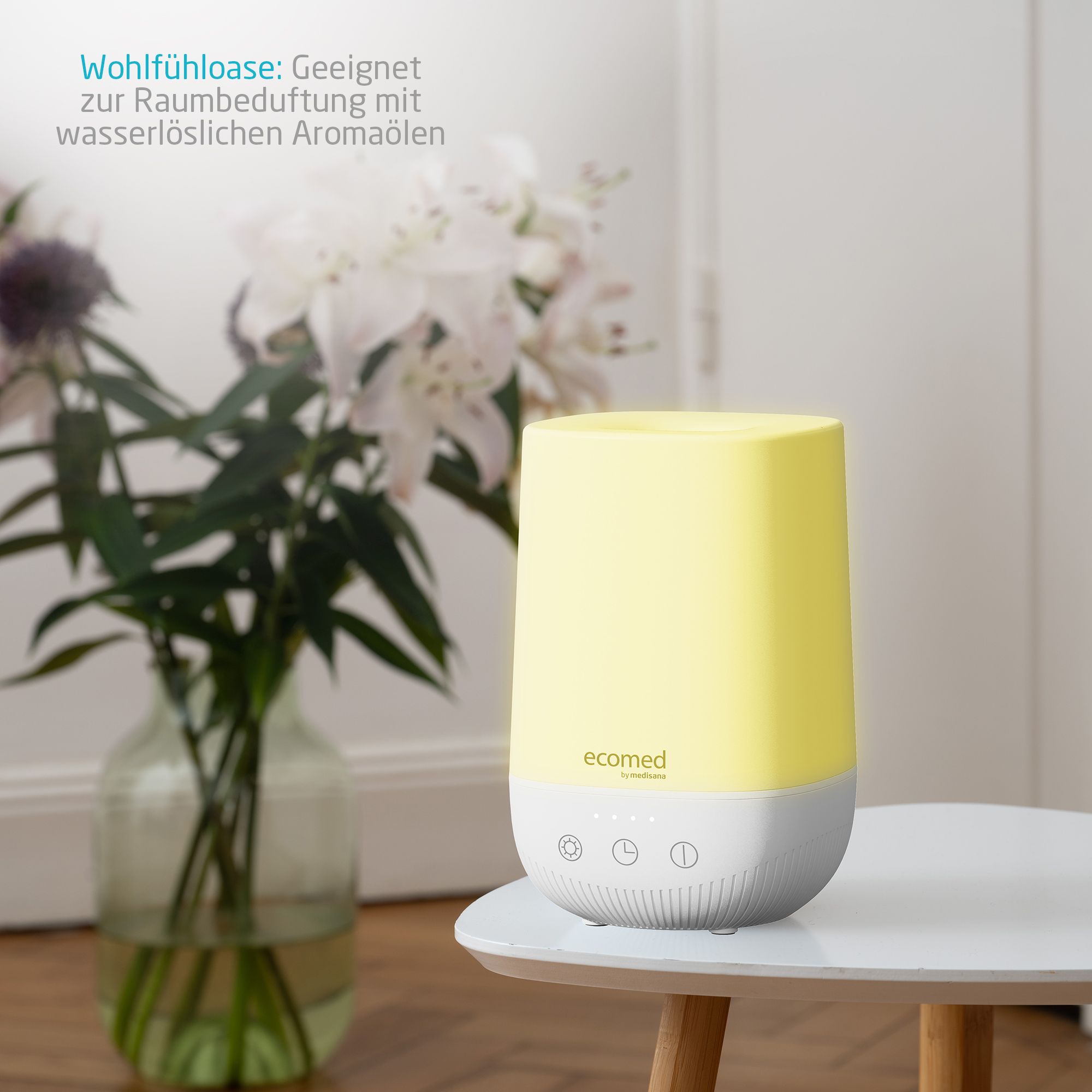 Verlichte ecomed AD-50E aromadiffuser in geel op een tafel naast bloemen.