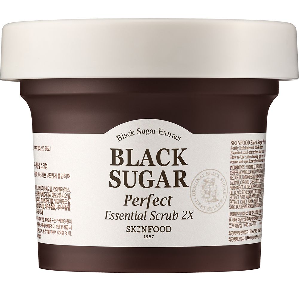 Donkerbruine pot met witte deksel. Opschrift: BLACK SUGAR Perfect Essential Scrub 2X. SKINFOOD logo en tekst.